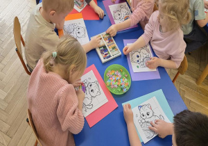 Dzieci wykonują prace plastyczną z okazji Dnia kota