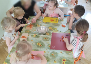Dzieci uczą się jak prawidło posługiwać się nożem podczas krojenia warzyw