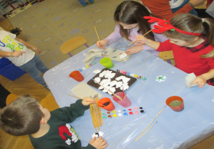 Malowanie gipsowych figurek na choinkę przez dzieci