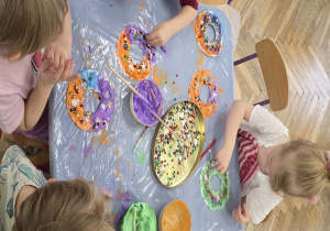 Dzieci wykonują pączki z pianki do golenia i i dekorują je