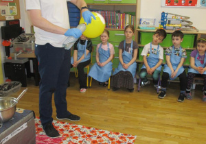 Dzieci oglądają eksperyment jak balon napełnia się dwutlenkiem węgla