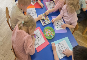 Dzieci wykonują prace plastyczną z okazji Dnia kota